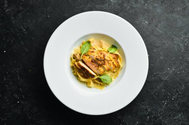 Tavuk fileto, peynir ve ıspanaklı makarna. İtalyan mutfağı. Menü. Üst görünüm.