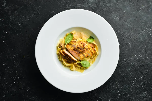 Tavuk fileto, peynir ve ıspanaklı makarna. İtalyan mutfağı. Menü. Üst görünüm.