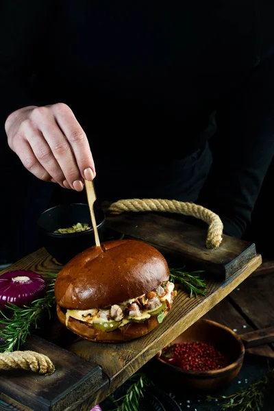 厨师手里拿着多汁的汉堡包 泡菜和奶酪酱 快餐概念 — 图库照片
