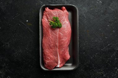 Dana bifteği. organik çiğ et fileto bifteği, siyah kayrak taşı arka planda. Üst Manzara. Çiğ et.