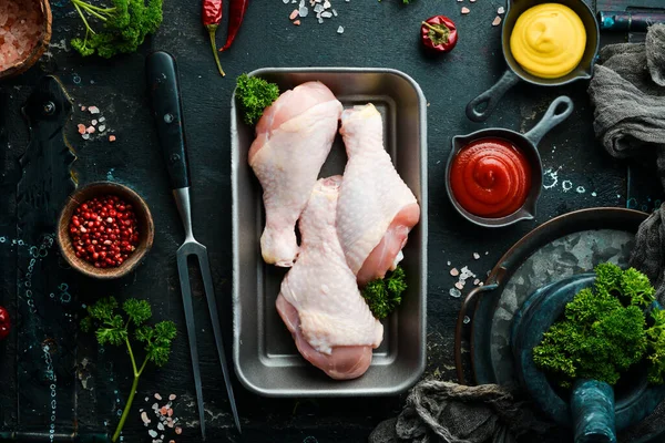 Chicken meat. Raw fresh chicken drumsticks on black slate stone background. Top view. Raw meat.