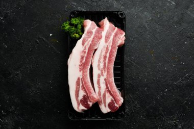 Domuz eti. Siyah taştan arka planda çiğ domuz pirzolası. Üst Manzara. Yemek pişirme.