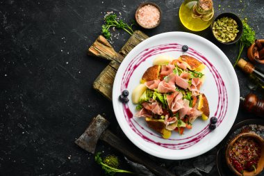 Prosciutto salatası, peynir ve sebzeler beyaz tabakta. Üst Manzara. Kırsal biçim.