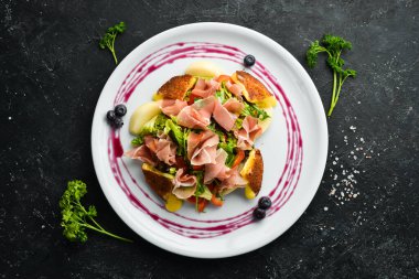 Beyaz tabakta jambonlu salata, peynir ve sebze. Üst Manzara. Kırsal biçim.