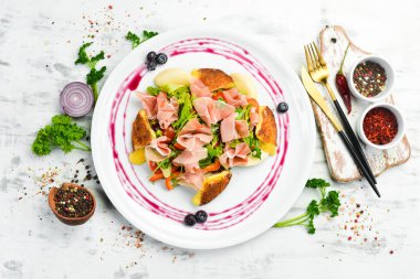 Prosciutto salatası, peynir ve sebzeler beyaz tabakta. Üst Manzara. Kırsal biçim.