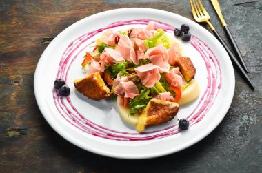 Prosciutto salatası, peynir ve sebzeler beyaz tabakta. Üst Manzara. Kırsal biçim.