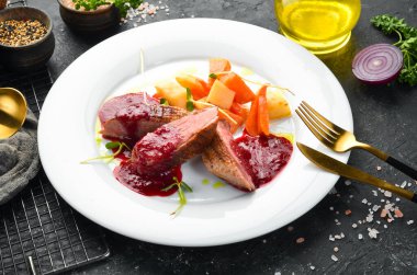 Kereviz kökü ve beyaz tabakta sebzeli fırında ördek göğsü. Üst Manzara. Kırsal biçim.