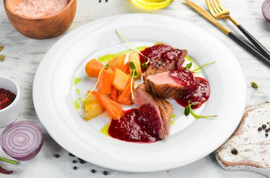 Kereviz kökü ve beyaz tabakta sebzeli fırında ördek göğsü. Üst Manzara. Kırsal biçim.