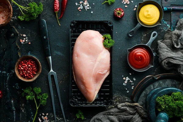 Chicken meat. Raw fresh chicken breast on black slate stone background. Top view. Raw meat.