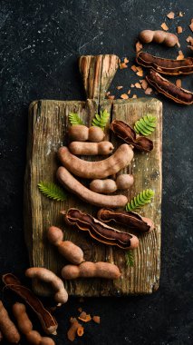 Mutfak tahtasındaki olgun demirhindi. Taş zeminde. Üst görünüm.