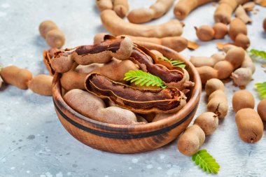 Yapraklı taze olgun demirhindi, sağlıklı meyve. Yan görüş. Taş bir arka planda.