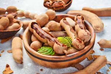 Yapraklı taze olgun demirhindi, sağlıklı meyve. Yan görüş. Taş bir arka planda.