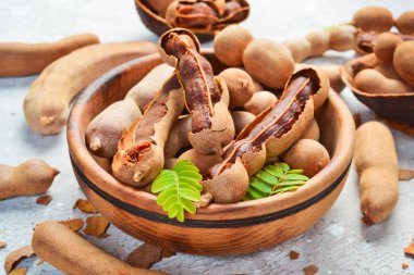 Yapraklı taze olgun demirhindi, sağlıklı meyve. Yan görüş. Taş bir arka planda.