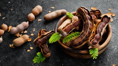 Yapraklı taze olgun demirhindi, sağlıklı meyve. Yan görüş. Taş bir arka planda.