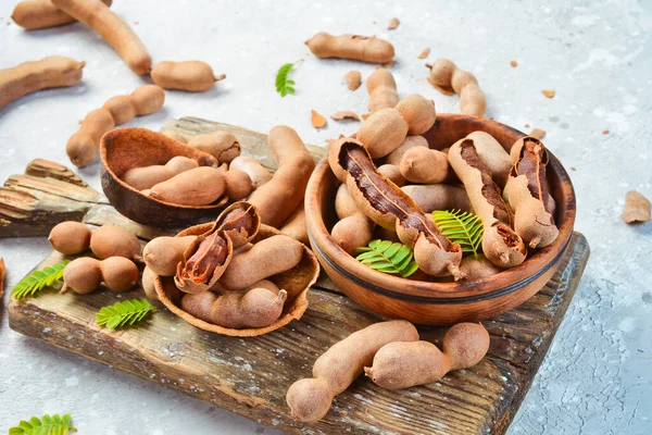 Yapraklı taze olgun demirhindi, sağlıklı meyve. Yan görüş. Taş bir arka planda.