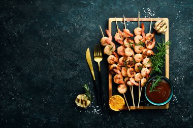 Deniz ürünleri. Kaplan karidesler. Şişte kızartılmış karides. Taş zeminde. Üst görünüm.