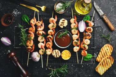 Deniz ürünleri. Kaplan karidesler. Şişte kızartılmış karides. Taş zeminde. Üst görünüm.