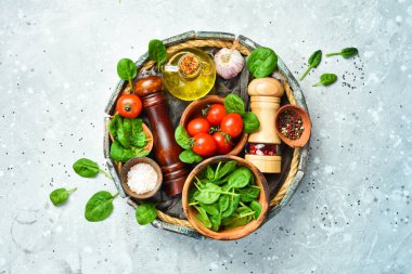 Pişirme geçmişi: domates, ıspanak, yağ, biber, baharat ve sebze. Üst Manzara. Taş bir arka planda.