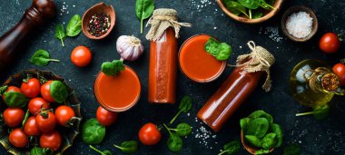 Cam şişelerde ev yapımı domates suyu. Üst Manzara. Taş bir arka planda.