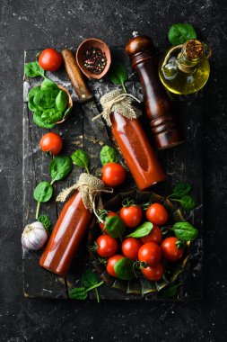 Cam şişelerde ev yapımı domates suyu. Üst Manzara. Taş bir arka planda.