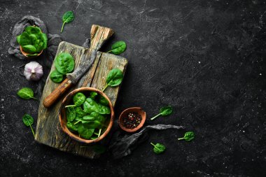 Kasede taze yeşil ıspanak. Siyah taştan bir arka planda. Üst görünüm.