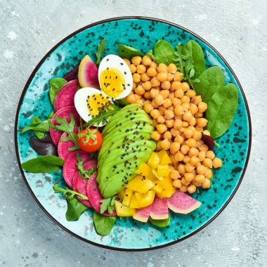 Buda kasesi: nohut, avokado, yumurta, karpuz turpu ve ıspanak. Taş zeminde lezzetli dengeli beslenme kavramı.