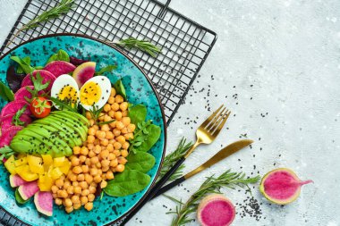 Buda kasesi: nohut, avokado, yumurta, karpuz turpu ve ıspanak. Taş zeminde lezzetli dengeli beslenme kavramı.