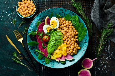 Diyet salatası: Nohut, ıspanak, turp, avokado ve yumurta. Buda 'yı oynat. Vejetaryen yemeği. Üst Manzara. Taş bir arka planda.