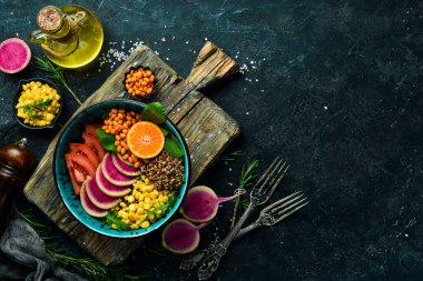 Buda kasesi: kinoa, ıspanak, mısır, domates ve karpuz turpu, deniz dikenleri. Sağlıklı vejetaryen yemekleri, süper yemekler. Taş bir arkaplanda en üstteki görünüm.