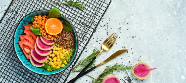 Buda kasesi: kinoa, ıspanak, mısır, domates ve karpuz turpu, deniz dikenleri. Taş zeminde lezzetli dengeli beslenme kavramı.