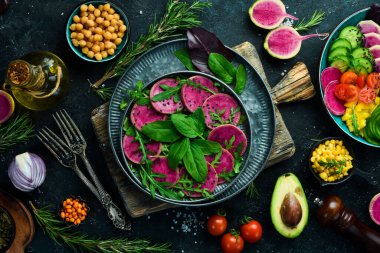 Taze sağlıklı salata: ıspanak, turp karpuzu, siyah susam ve zeytinyağı. Sağlıklı yiyecekler. Üst Manzara. Taş bir arka planda.