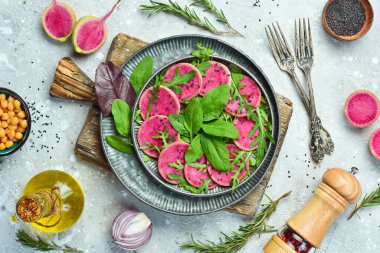 Taze sağlıklı salata: ıspanak, turp karpuzu, siyah susam ve zeytinyağı. Sağlıklı yiyecekler. Üst Manzara. Taş bir arka planda.