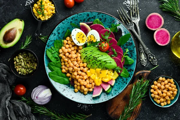 Dengeli yiyecek: nohut, avokado, yumurta, karpuz turpu ve ıspanak. Buda kasesi taş zeminde lezzetli yemek konsepti.