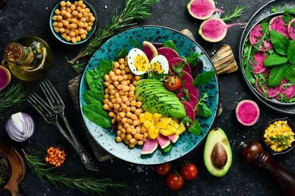 Diyet salatası: Nohut, ıspanak, turp, avokado ve yumurta. Buda 'yı oynat. Vejetaryen yemeği. Üst Manzara. Taş bir arka planda.