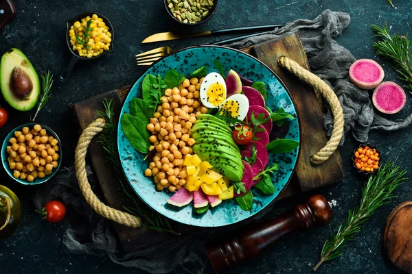 Diyet salatası: Nohut, ıspanak, turp, avokado ve yumurta. Buda 'yı oynat. Vejetaryen yemeği. Üst Manzara. Taş bir arka planda.