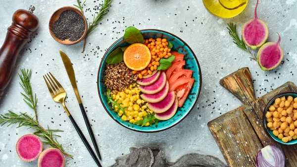 Buda kasesi: kinoa, ıspanak, mısır, domates ve karpuz turpu, deniz dikenleri. Taş zeminde lezzetli dengeli beslenme kavramı.