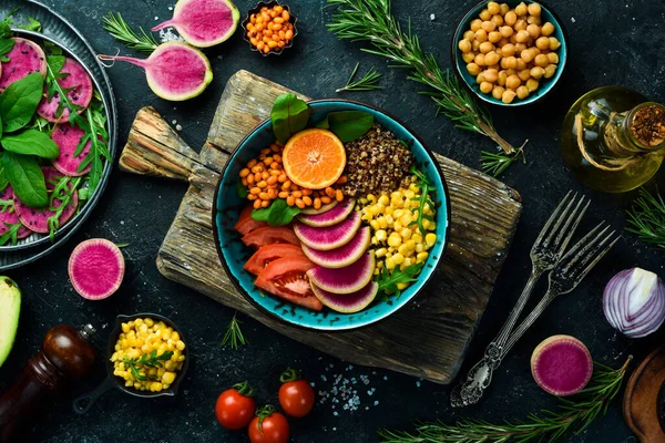 Sebze diyet salatası: kinoa, ıspanak, mısır, domates ve turp karpu. Buda 'yı oynat. Vejetaryen yemeği. Üst Manzara. Taş bir arka planda.