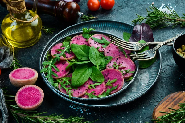 Taze sağlıklı salata: ıspanak, turp karpuzu, siyah susam ve zeytinyağı. Sağlıklı yiyecekler. Üst Manzara. Taş bir arka planda.