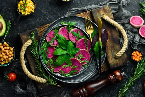 Taze sağlıklı salata: ıspanak, turp karpuzu, siyah susam ve zeytinyağı. Sağlıklı yiyecekler. Üst Manzara. Taş bir arka planda.