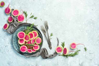 Tabakta pembe karpuz turpu dilimleri. Beslenme amaçlı sebzeler. Gri taştan bir arka planda.