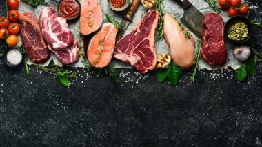 Et seti. Balık biftek, dana biftek ve tavuk göğsü. Üst Manzara. Siyah taştan bir arka planda.