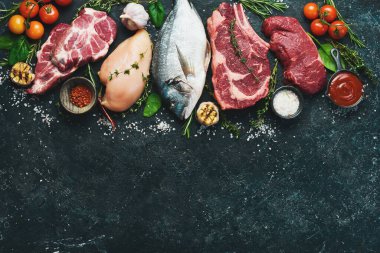 Çeşitli protein kaynakları konsepti - kaburga, dorado, domuz eti, yumurta. Üst Manzara. Siyah taştan bir arka planda.