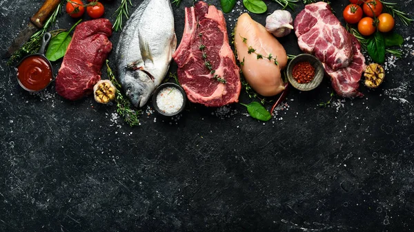 Çeşitli protein kaynakları konsepti - kaburga, dorado, domuz eti, yumurta. Üst Manzara. Siyah taştan bir arka planda.