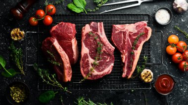 Baharatlı ızgara için çeşitli çiğ biftekler, biftek, biftek, pirzola. Üst Manzara. Siyah taştan bir arka planda.