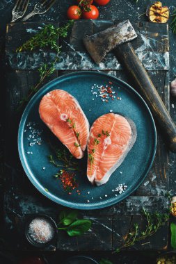 Balık. Çiğ somon ya da tabakta alabalık bifteği. Üst Manzara. Siyah taştan bir arka planda.