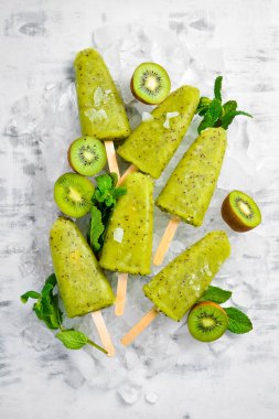 Ev yapımı buzlu kivi, limon ve nane. Tahta arka planda meyveli şerbet. Üst Manzara. Beyaz bir arkaplanda.