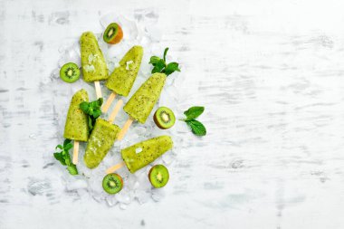 Ev yapımı buzlu kivi, limon ve nane. Tahta arka planda meyveli şerbet. Üst Manzara. Beyaz bir arkaplanda.