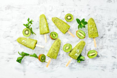 Ev yapımı buzlu kivi, limon ve nane. Tahta arka planda meyveli şerbet. Üst Manzara. Beyaz bir arkaplanda.