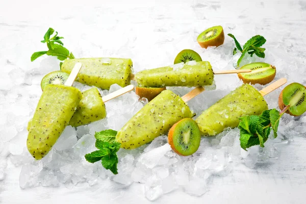 Ev yapımı buzlu kivi, limon ve nane. Tahta arka planda meyveli şerbet. Üst Manzara. Beyaz bir arkaplanda.