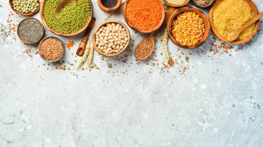 Taş zeminde bir kase baklagil, mercimek, nohut, fasulye, pirinç ve tahıl..